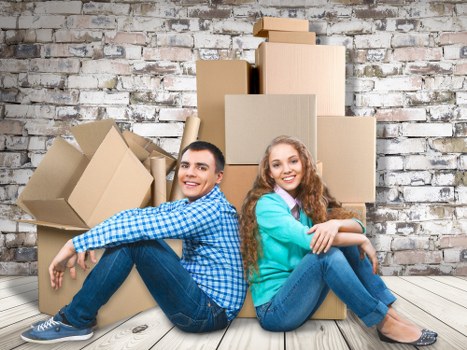 Professional movers carrying furniture in a residential Rush Green street